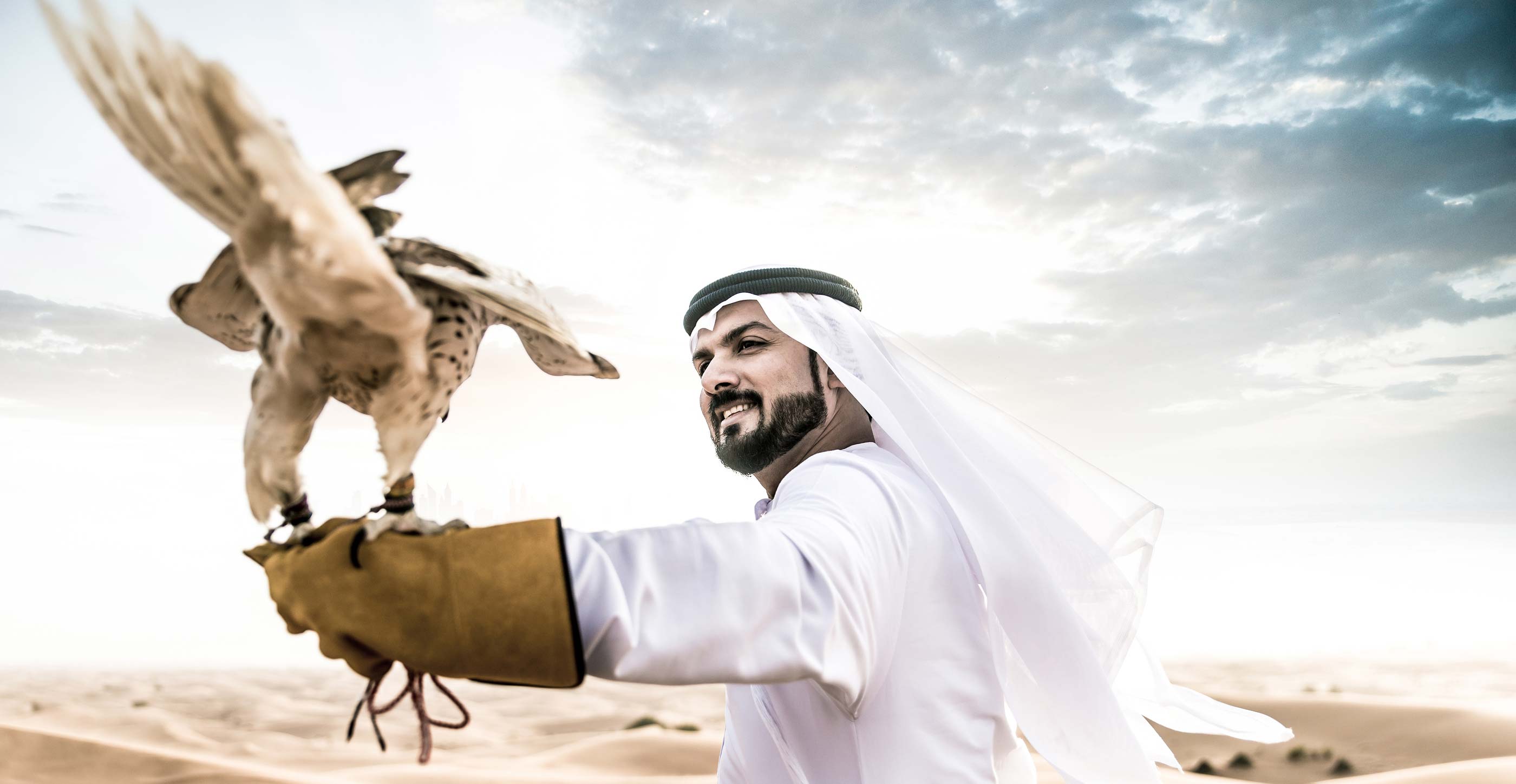 fotografia di un falco sul braccio di un uomo arabo